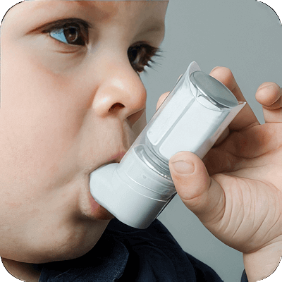 image of young boy using an inhaler