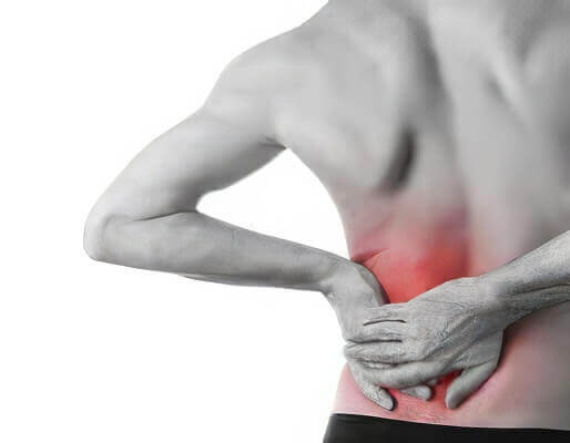 black and white image of a man holding his lower back in pain