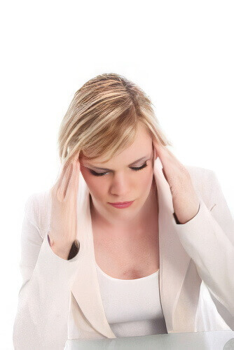 image of a woman closing her eyes while massaging her temples