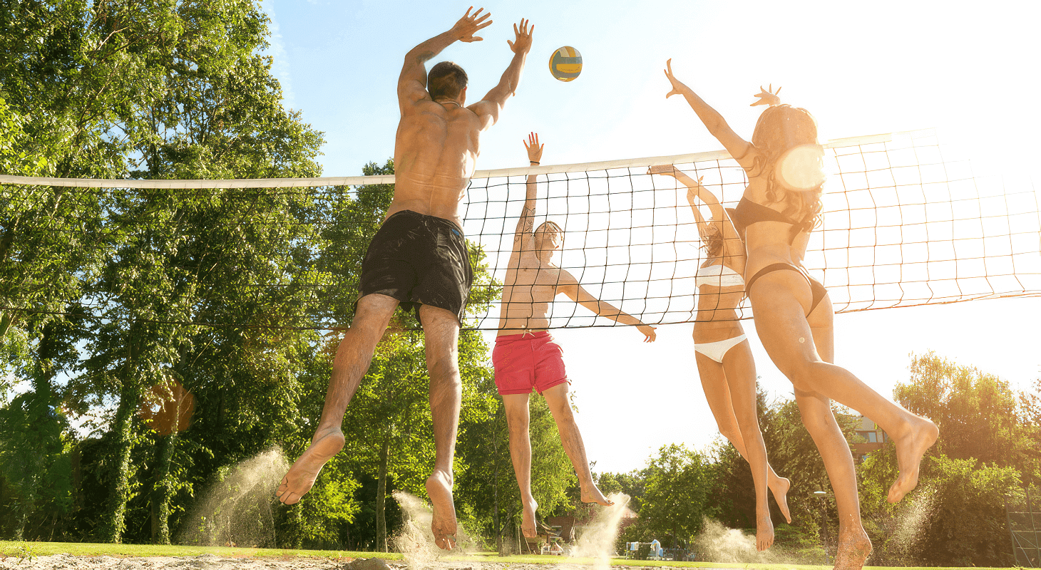 Group of young friends play volleyball on the beach