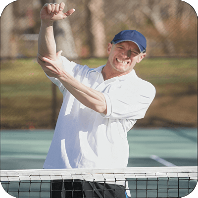 image of man at a tennis court holding his elbow
