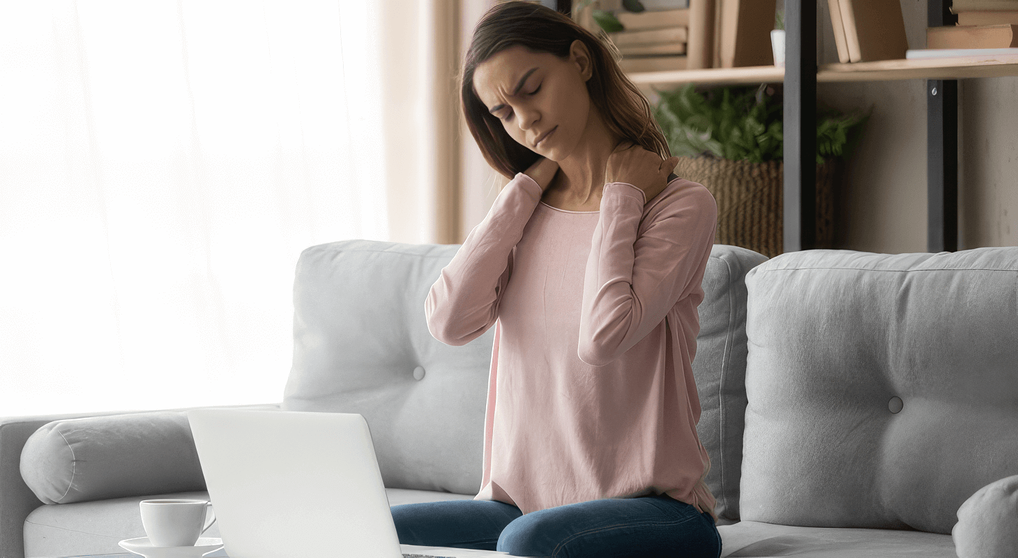 Woman experiences neck pain from working on her couch