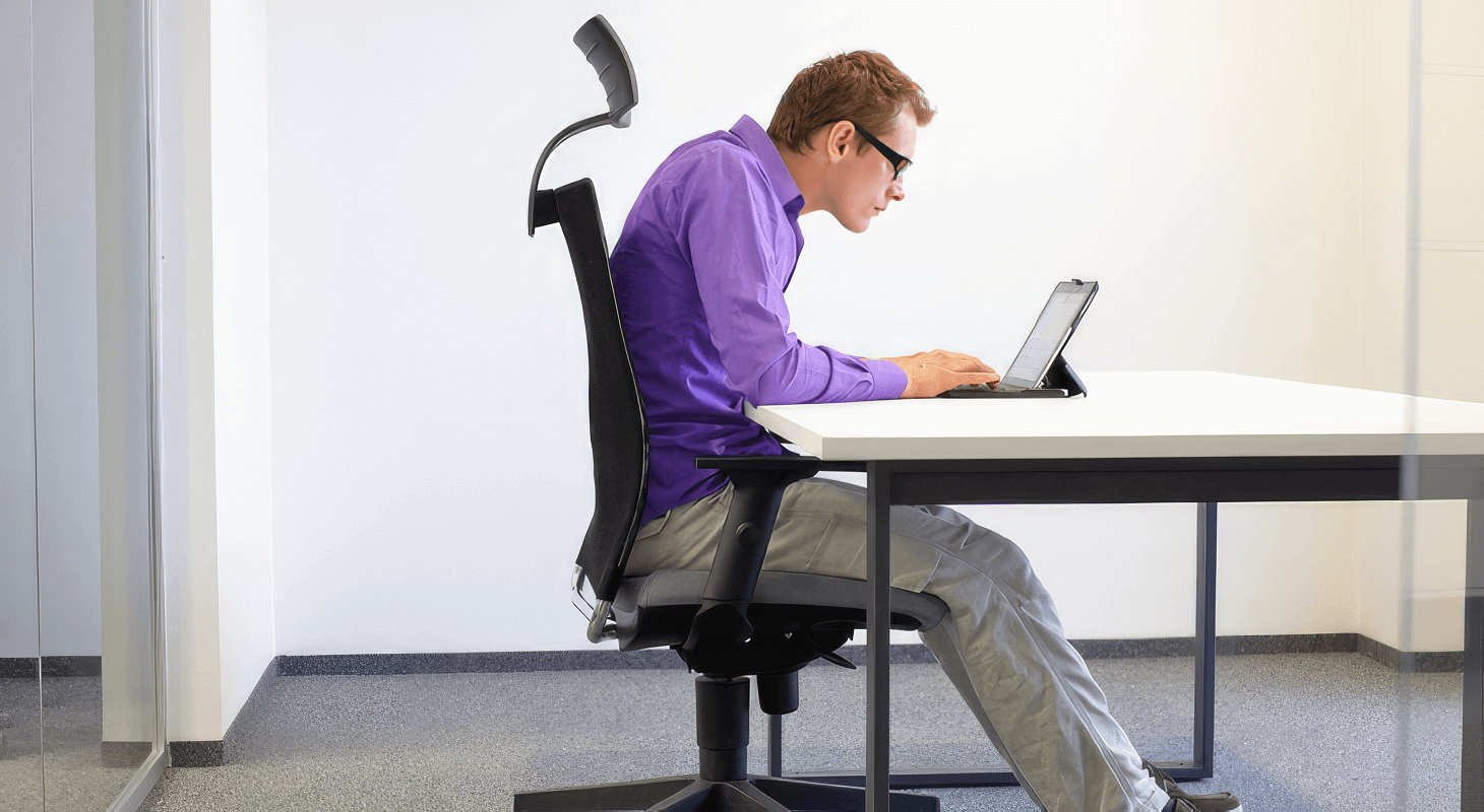 Young man hunched over laptop