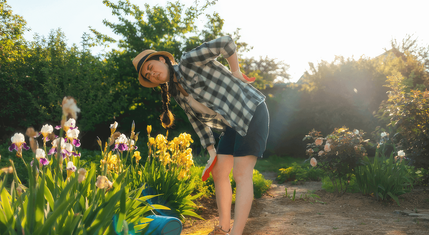 Young woman feels back pain while gardening